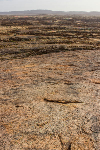 Granite summit surface of Moon Rock overlooking the rugged landscape of Augrabies Falls National Park, South Africa.
