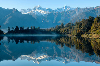Mirror reflections of the Southern Alps in Lake Matheson at dawn on the West Coast of New Zealand’s South Island.