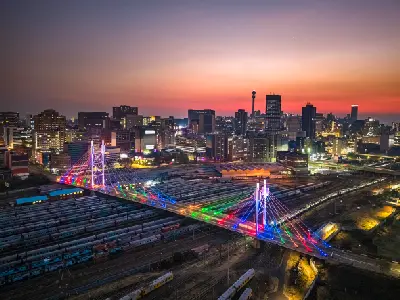 Aerial view of the Johannesburg skyline and Nelson Mandela Bridge at sunset in Gauteng, South Africa.