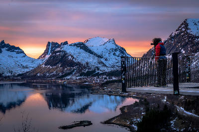 Photographer standing on Bergsbotn platform above Bergsfjord at sunset in Senja