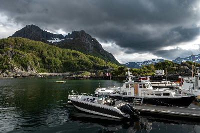 Boats moored in Hamn i Senja harbour with mountains and fjord on Senja island, Norway