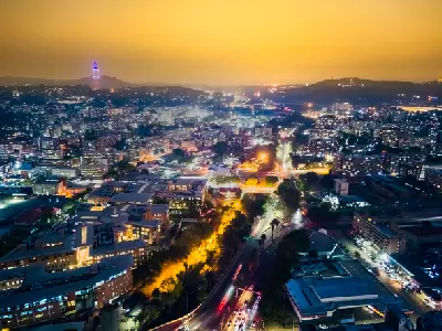 Aerial view of Pretoria at dusk with illuminated streets, city buildings and surrounding hills in Gauteng, South Africa.