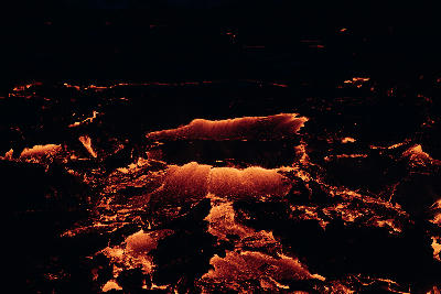 Glowing molten lava rivers at night during the Fagradalsfjall volcanic eruption on the Reykjanes Peninsula, Iceland.