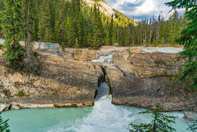 Kicking Horse River rushing through a narrow rock channel at Natural Bridge in Yoho National Park