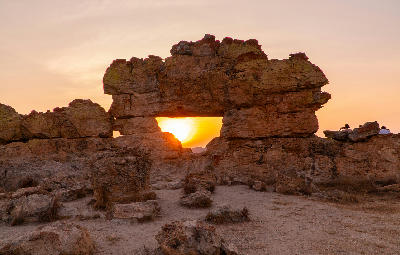 Natural sandstone window formation glowing at sunset in the eroded canyon landscapes of Isalo National Park, Madagascar