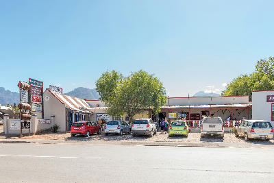 Karoo Ville shopping area and wine outlets in Ladismith along Route 62, with mountains rising behind the town in the Klein Karoo, Western Cape, South Africa.