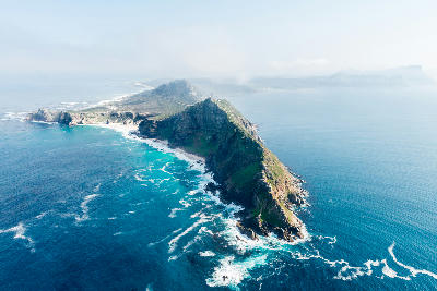 Aerial view of Cape Point showing steep cliffs and a narrow peninsula surrounded by the Atlantic Ocean.