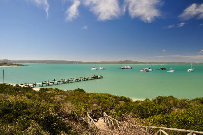 Boardwalk and jetty overlooking the turquoise waters and houseboats of Kraalbaai in West Coast National Park.