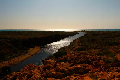 Late sunlight reflects along Yardie Creek as it winds through Cape Range toward the Indian Ocean.