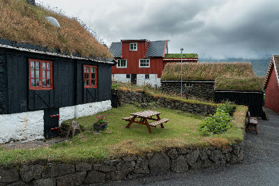 Old wooden houses with grass roofs and stone walls in Elduvík, Eysturoy, Faroe Islands.