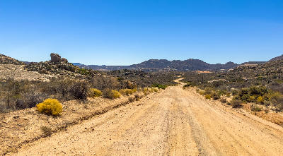 Remote gravel road crossing the rocky Kamiesberg mountains in Namaqualand, Northern Cape, South Africa.