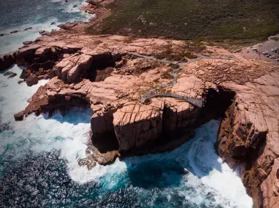 Aerial view of The Gap, its cantilevered lookout and waves breaking against granite cliffs in Torndirrup National Park near Albany, Western Australia.