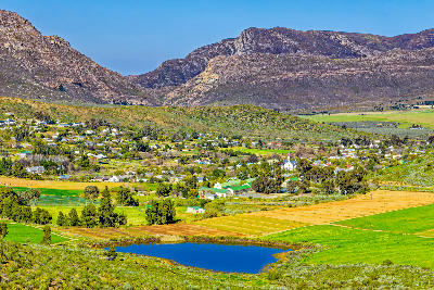 Panoramic landscape of Barrydale surrounded by farmland and mountain ridges in the Tradouw Valley of the Western Cape, South Africa.