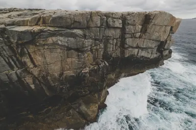 Waves breaking against steep granite cliffs beside Natural Bridge in Torndirrup National Park, Western Australia.