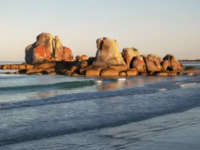 Orange lichen-covered granite formations at Picnic Rocks near Eddystone Point, Tasmania.