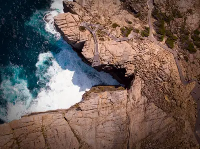 Aerial view of The Gap, its cantilevered lookout and waves surging into the granite chasm in Torndirrup National Park near Albany, Western Australia.