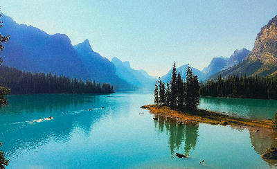 Spirit Island on Maligne Lake with turquoise water, small forested island, and distant mountain silhouettes