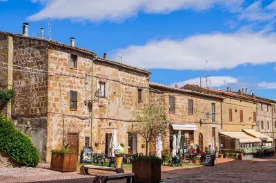 Stone buildings and café terraces in the historic centre of Sovana in the Maremma region of Tuscany, Italy.