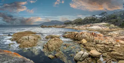 Granite rocks and tidal pools at dusk at Binalong Bay in the Bay of Fires, Tasmania, Australia.
