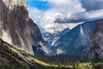 Tunnel View in Yosemite National Park showing El Capitan, Bridalveil Fall, and Yosemite Valley with granite cliffs under dramatic clouds.