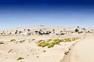 Entrance road and abandoned buildings in Kolmanskop ghost town near Lüderitz, Namibia.
