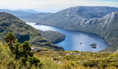 Elevated view over Dove Lake surrounded by rugged mountains and alpine vegetation in Tasmania, Australia.