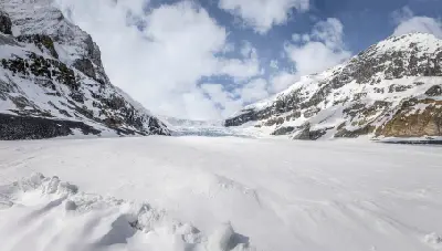 Athabasca Glacier flowing between snow-covered peaks in Jasper National Park, Alberta, Canada