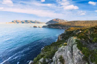 View from Cape Tourville across rocky headlands and blue coastal waters in Freycinet National Park, Tasmania.