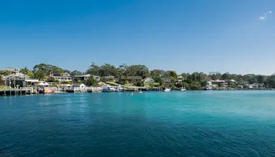 Turquoise water along the Huskisson waterfront, with jetties, boats and homes lining the shore of Jervis Bay.