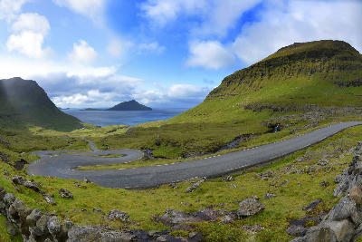 Curving road leading into Norðradalur valley toward Koltur island on Streymoy, Faroe Islands.