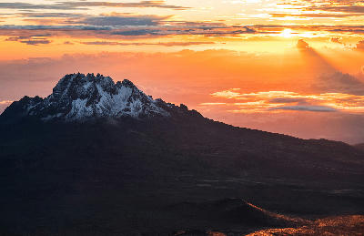 Sunrise illuminating Mawenzi Peak (5,149 m) beyond the Saddle on Mount Kilimanjaro, Tanzania, with the high-altitude volcanic plateau in the foreground at approximately 4,700 metres above sea level.