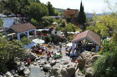 Visitors and locals gathering beside the Ras El Maa spring in Chefchaouen, Morocco