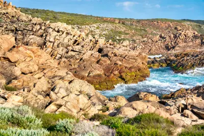 Turquoise seawater flowing through rugged granite rocks at Injidup Natural Spa on the Margaret River coast of Western Australia.