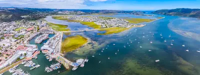 Aerial view of the Knysna Lagoon, showing tidal channels, islands, marinas and waterfront neighbourhoods within South Africa's largest estuary system on the Garden Route.