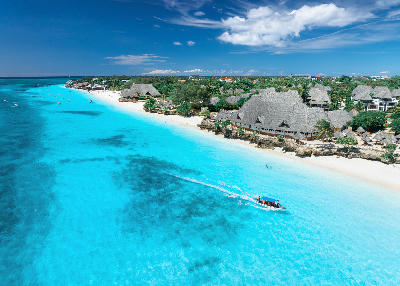 Drone view of Nungwi Beach with white sand, turquoise Indian Ocean, palm-fringed resorts, and tropical coastline, Zanzibar, Tanzania.