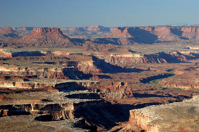 Elevated view from Green River Overlook showing river cutting through mesas, cliffs, and stratified canyon landscape in Canyonlands National Park Utah