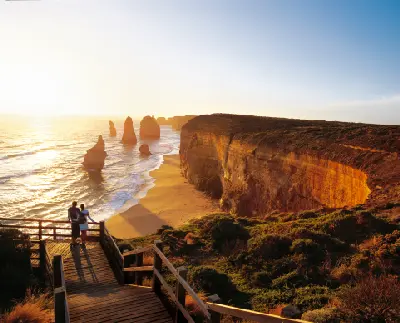 Visitors overlooking the Twelve Apostles and coastal cliffs at sunset on the Great Ocean Road, Victoria.