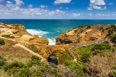 Wooden boardwalk descending through coastal cliffs to The Grotto beside the Southern Ocean, Victoria.