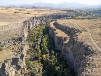 Elevated view of the Ihlara Valley gorge and its green, tree-lined canyon floor in Cappadocia, Turkey.