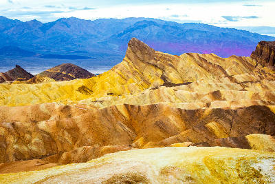 Zabriskie Point sunrise in Death Valley National Park California showing colorful badlands and Furnace Creek Formation ridges