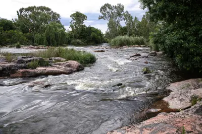Vaal River flowing through rocky channels and riverine vegetation in the Vredefort Dome, South Africa.