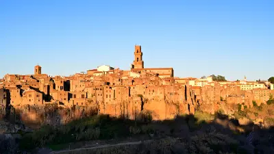 Golden hour view of the medieval hilltop town of Pitigliano built on volcanic tufa cliffs in southern Tuscany, Italy.
