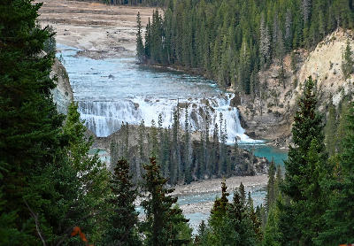 Wapta Falls cascading across the Kicking Horse River surrounded by forested canyon walls in Yoho National Park