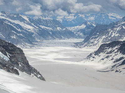 Aletsch Glacier stretching across a wide alpine basin beneath snow-covered peaks, viewed from Jungfraujoch, Switzerland.