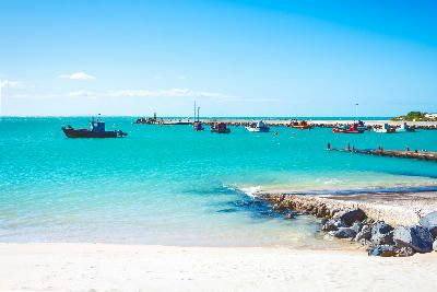 Fishing boats floating in the bright turquoise waters of Struisbaai Harbour near Cape Agulhas in the Western Cape, South Africa.