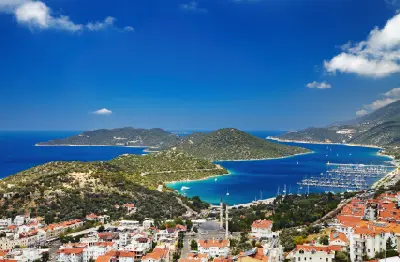 Panoramic view of Kaş, with its red-roofed town, marina, turquoise bays and the Çukurbağ Peninsula stretching into the Mediterranean.