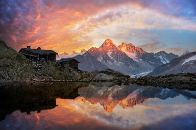 Lac Blanc at sunset with reflection of Mont Blanc Massif peaks and alpine hut in Chamonix, French Alps.