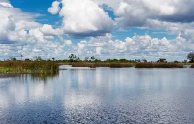 Panoramic view of the Selinda Spillway with reed-lined wetlands and dramatic clouds in the Linyanti region of northern Botswana.