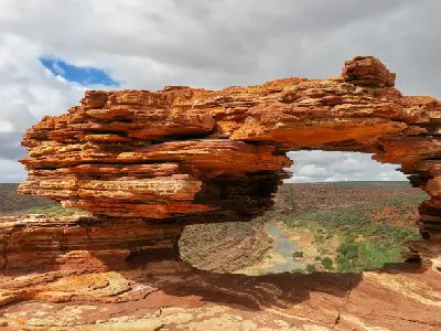 Close view through the layered red sandstone opening of Nature’s Window towards the Murchison River gorge.