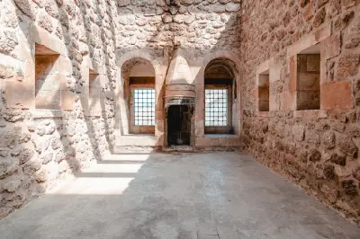 Historic stone chamber with arched windows and a traditional fireplace inside İshak Pasha Palace in Doğubayazıt, Turkey.